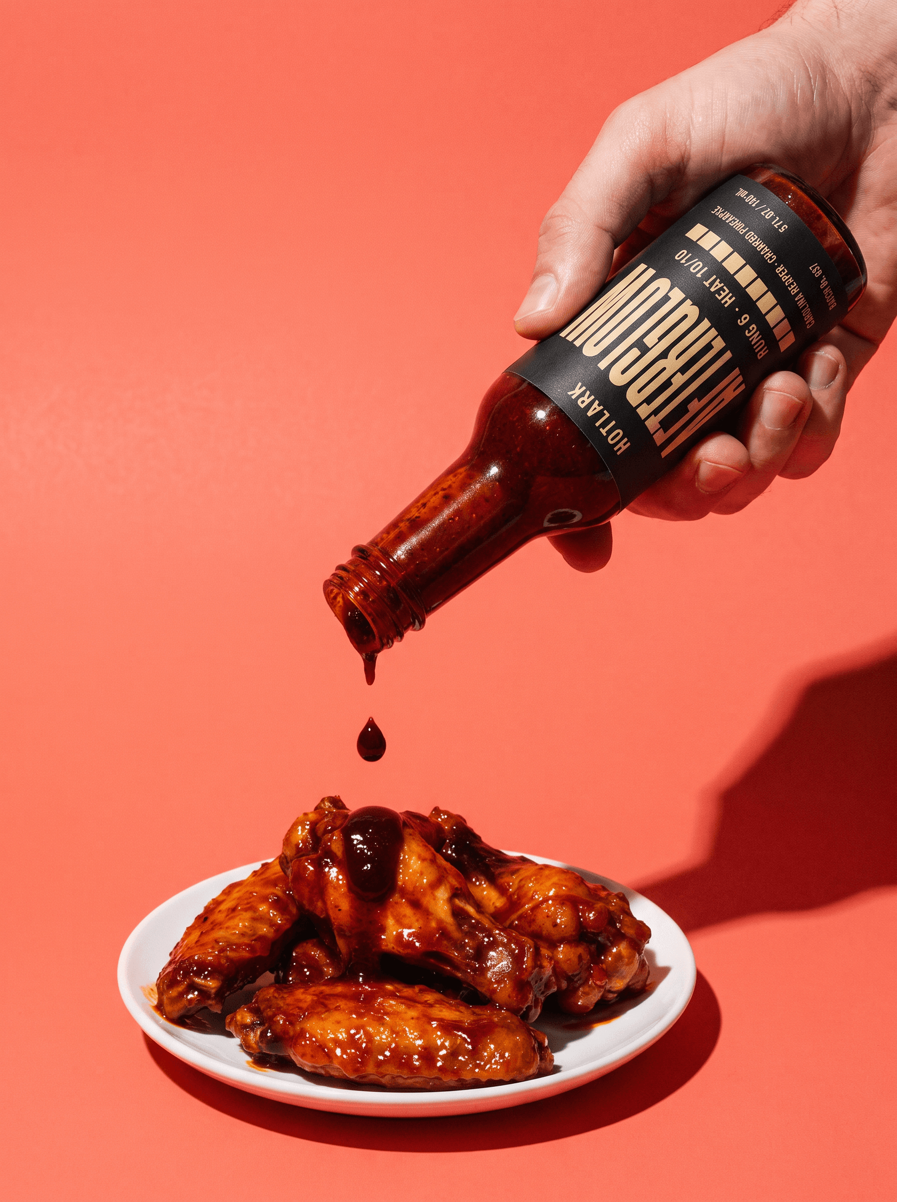 A single drop of Afterglow falling onto a chicken wing